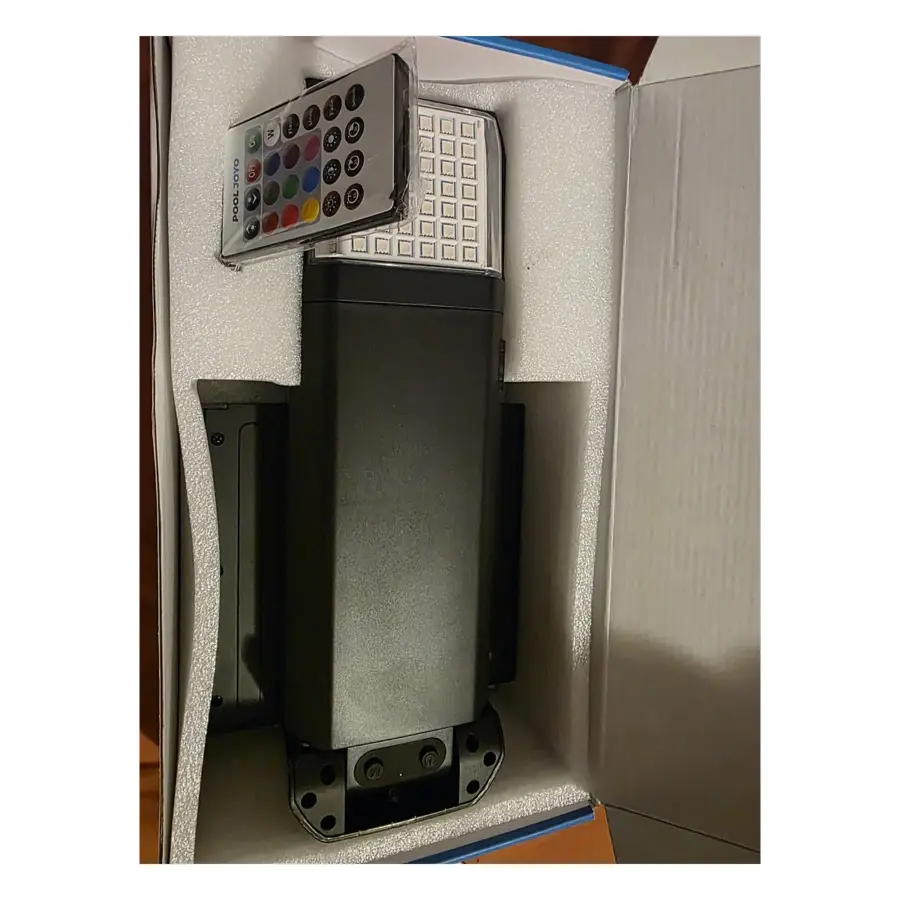 Open box Pool JOYO solar pool light in its foam insert, with the colour remote and LED panel visible